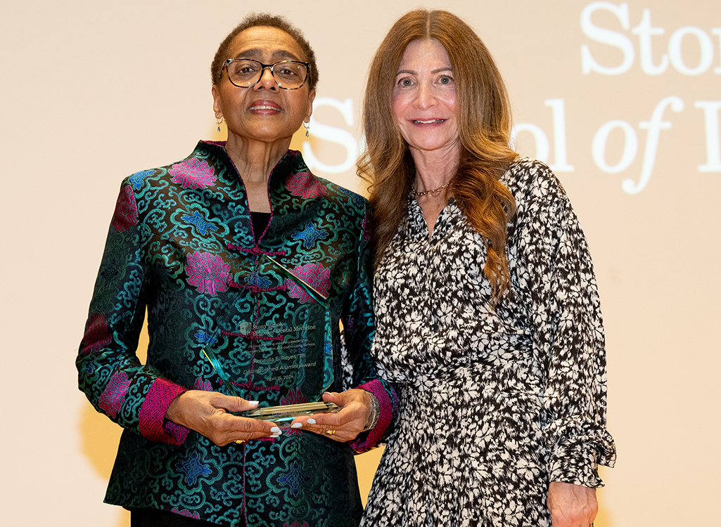 Dr. Reneida Reyes holding a plaque, alongside Dr. Stacy Reisfeld